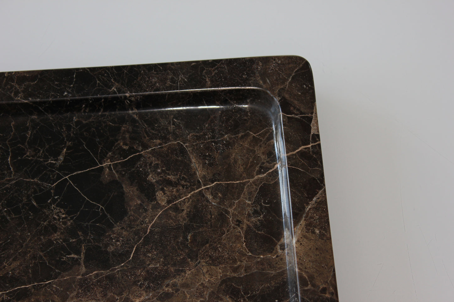 Close-up of the rounded inner edge of the Dark Emperador marble tray.