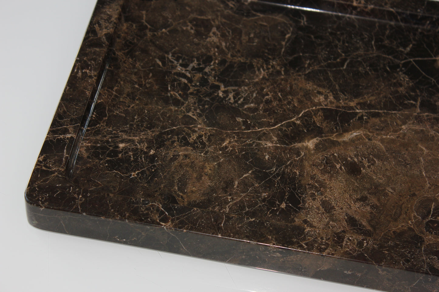 Close-up of the rounded polished corner of The Monolith Dark Emperador tray.