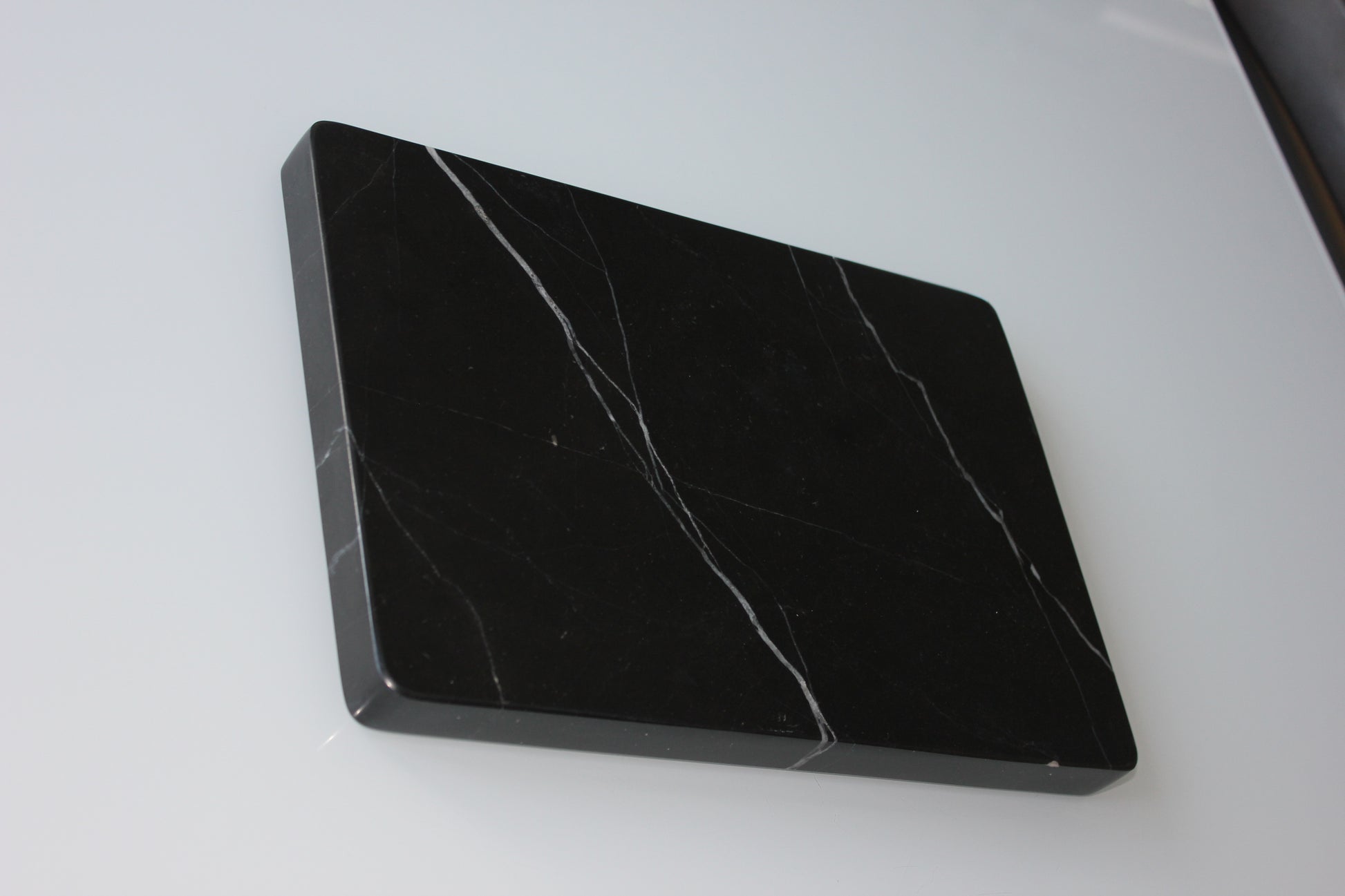 solid one-piece Nero Marquina marble tray showing the polished underside.