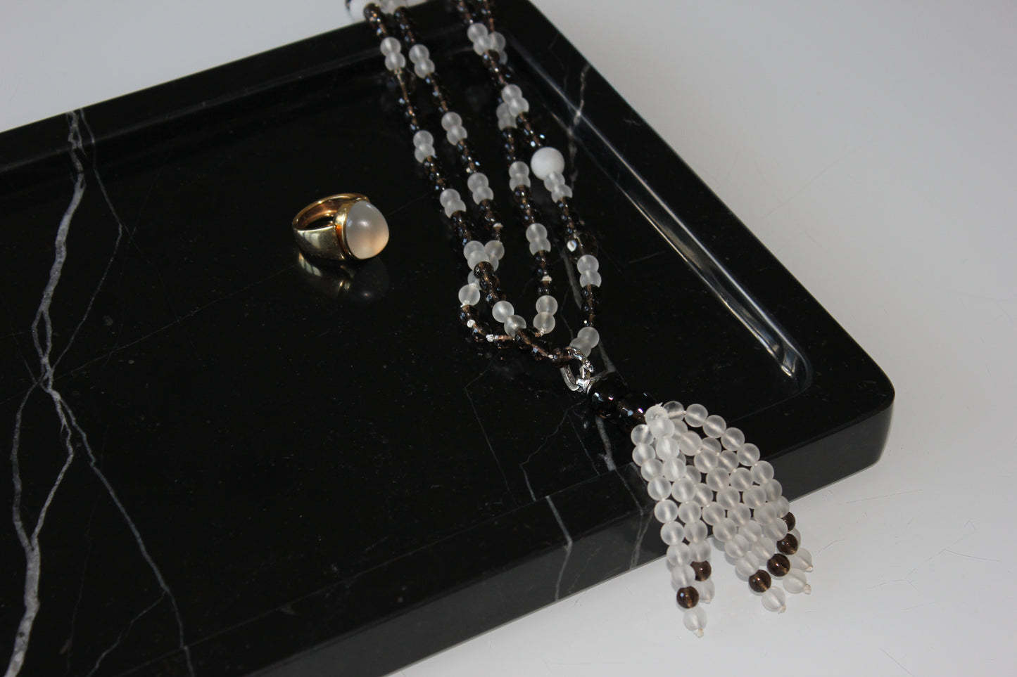 Jewellery displayed on The Monolith tray crafted from Nero Marquina marble.