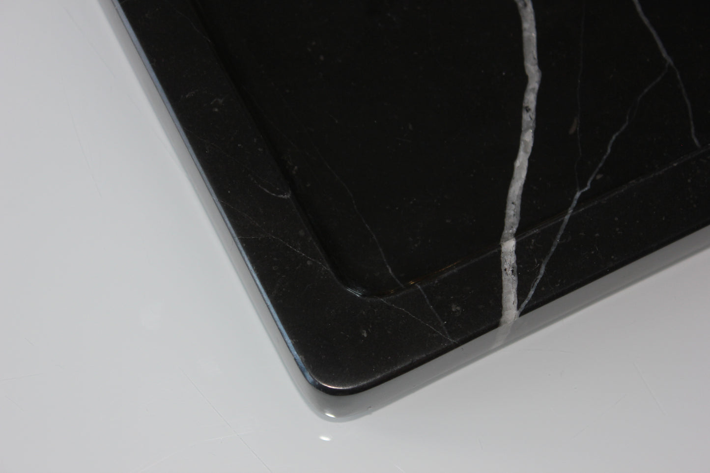 Close-up of the rounded corner and polished edge of The Monolith Nero Marquina tray.
